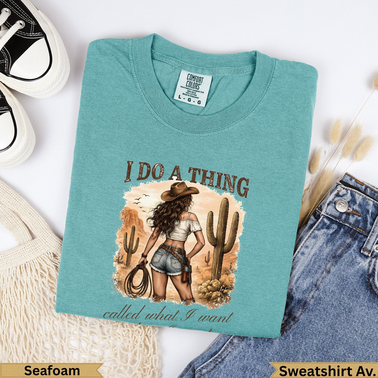 Teal graphic t-shirt with desert scene and "I do a thing called what I want" text.