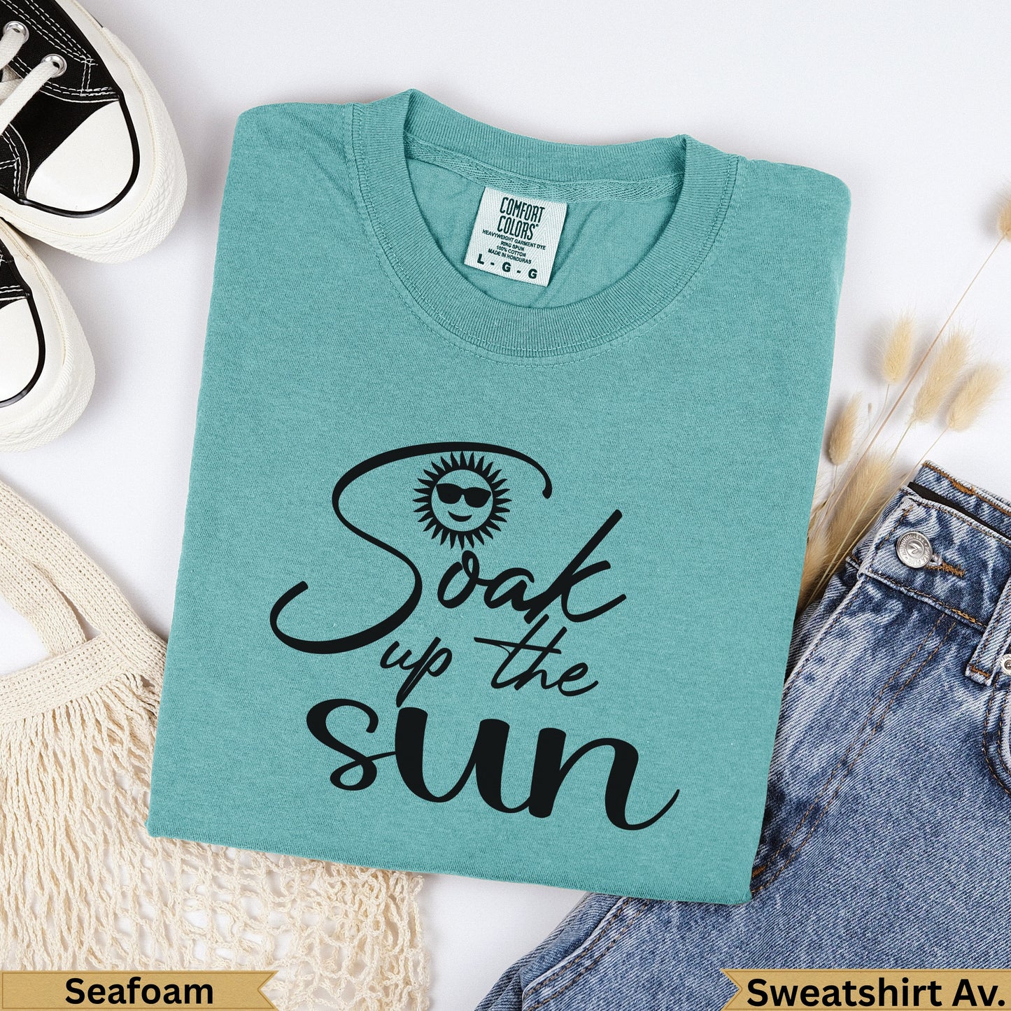 Teal t-shirt with "Soak up the sun" text and sun graphic.