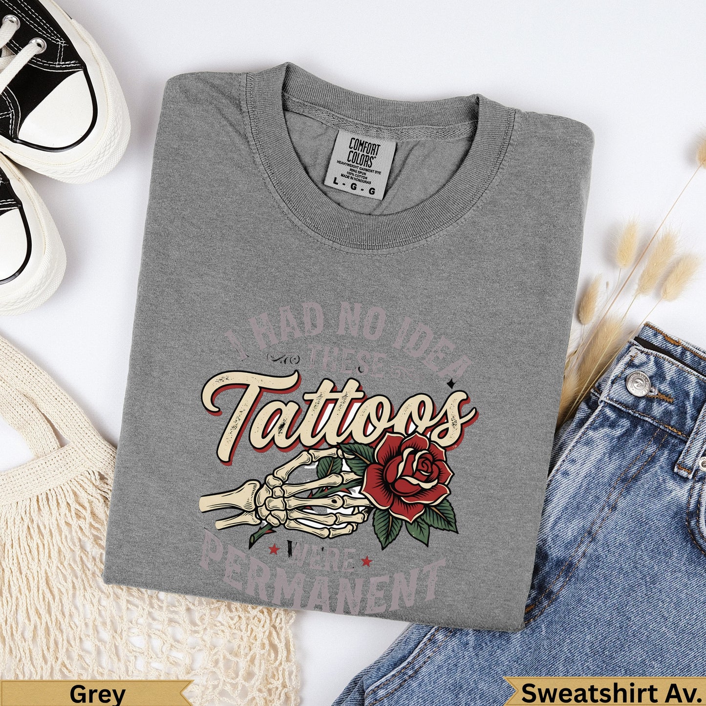 Grey t-shirt with skeleton hand, rose, and text "I had no idea tattoos were permanent".