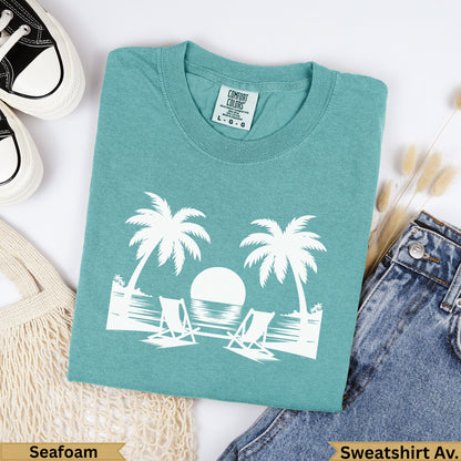 Teal Comfort Colors sweatshirt with palm trees, chairs, and ocean graphic.