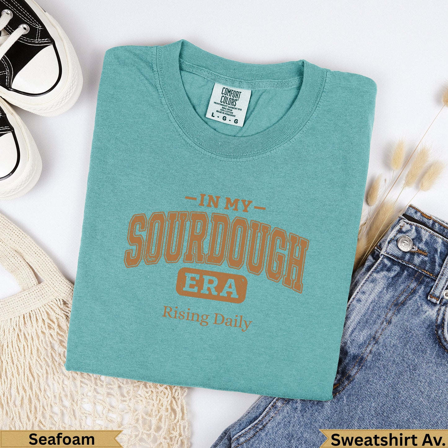 Teal graphic t-shirt with "In My Sourdough Era" and "Rising Daily" text.