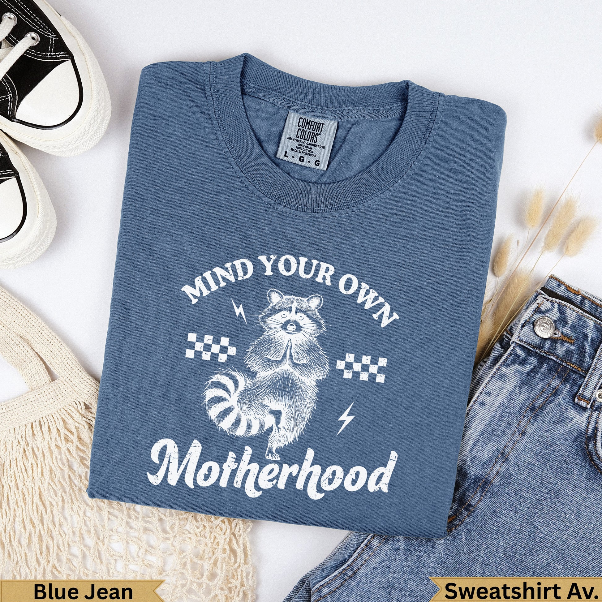 Blue Jean sweatshirt with "Mind Your Own Motherhood" and raccoon graphic.