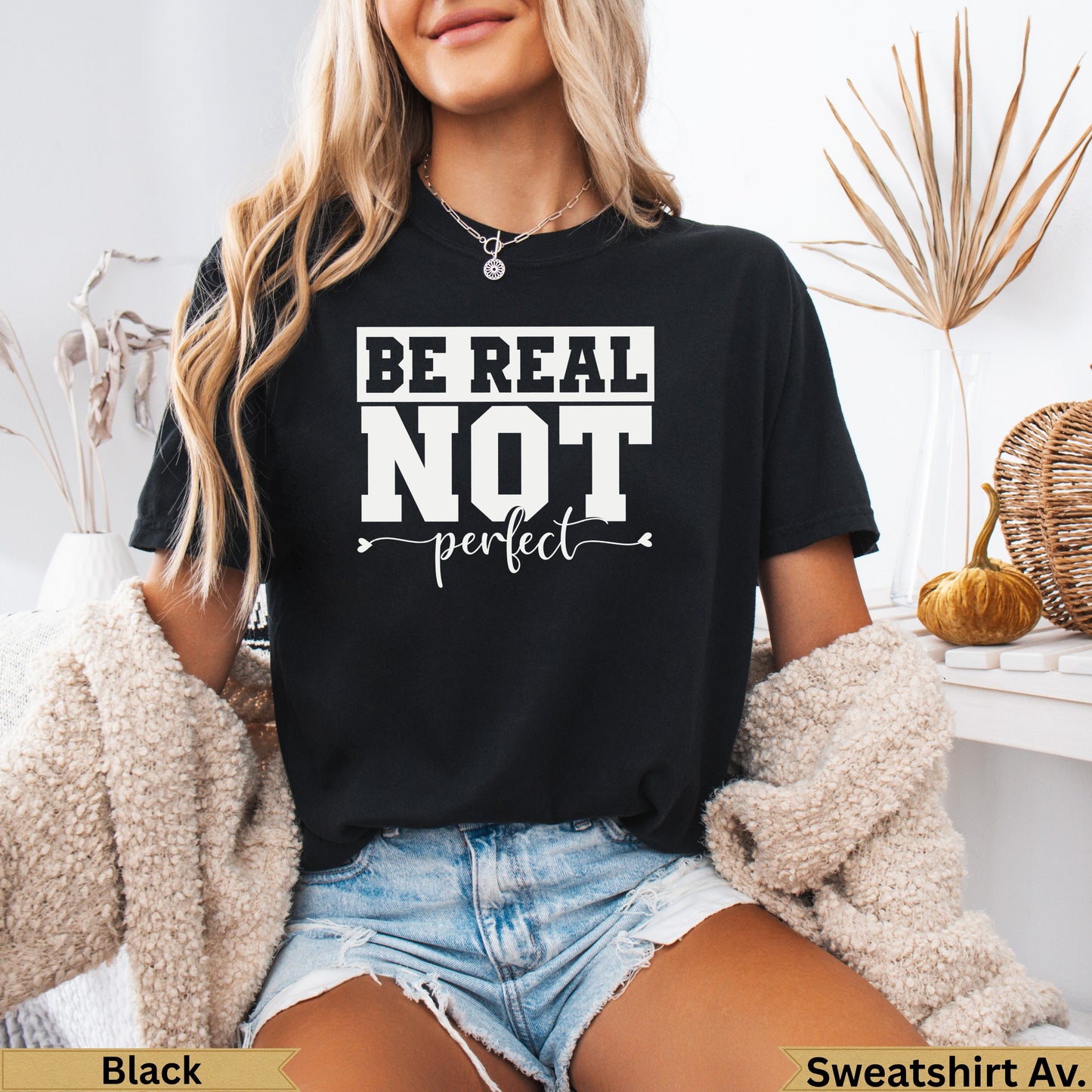 Black t-shirt with "BE REAL NOT perfect" text and small heart detail.