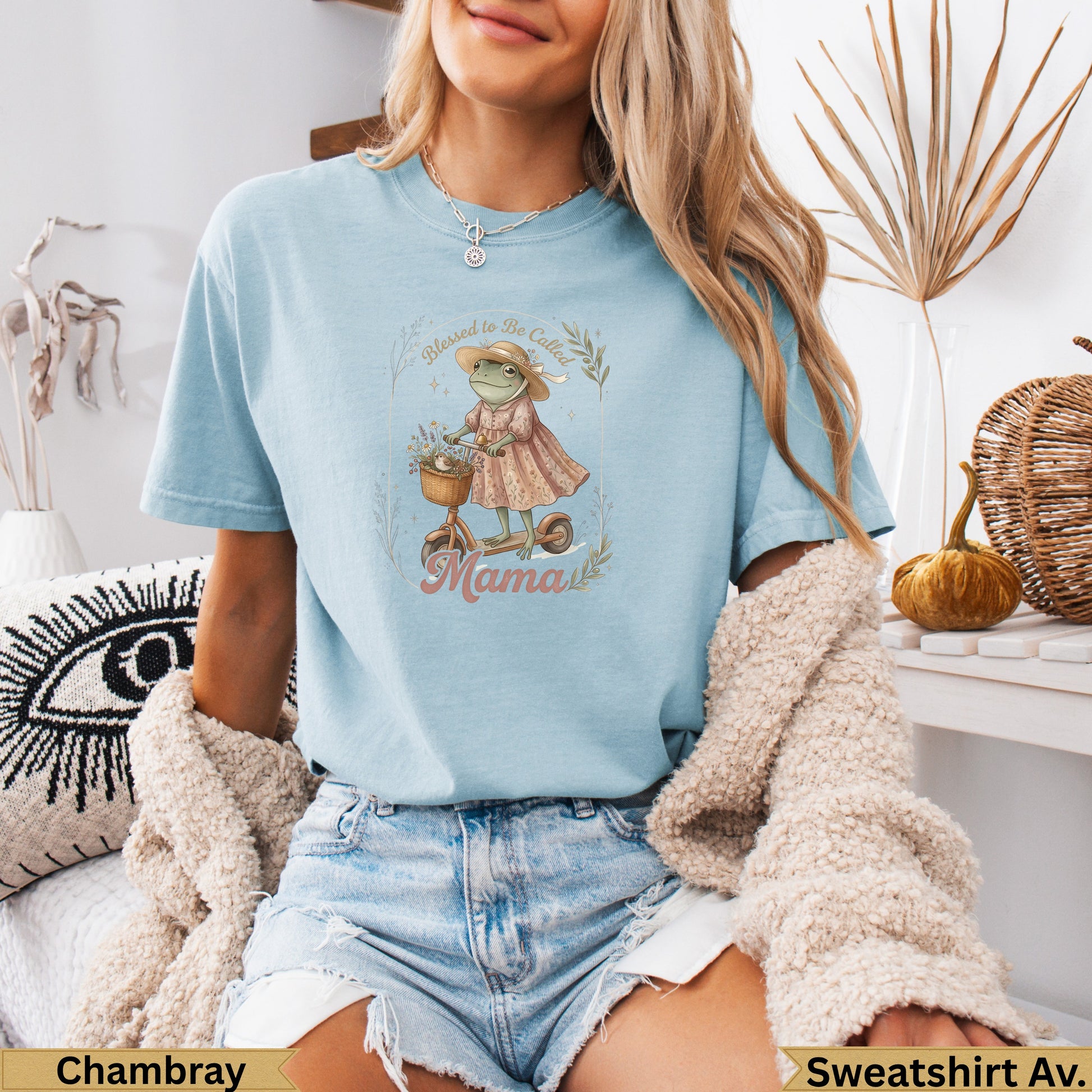 Light blue t-shirt with a graphic of a frog on a scooter with flowers.