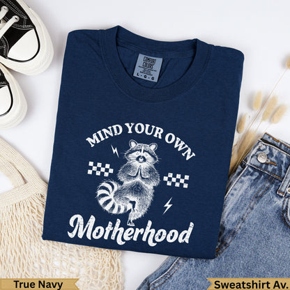 Navy blue graphic sweatshirt with raccoon and "Mind Your Own Motherhood" text.