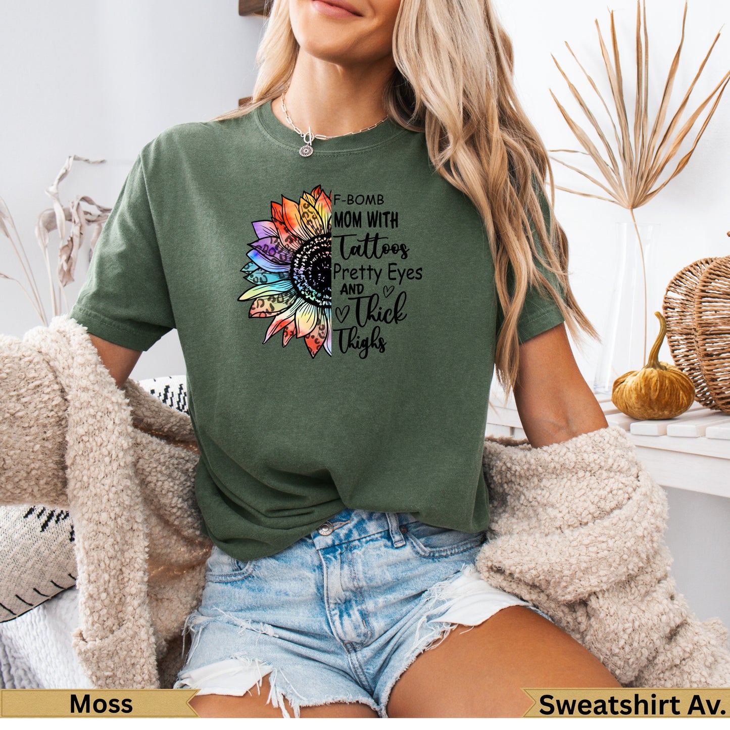Green t-shirt with floral "F-Bomb Mom with Tattoos Pretty Eyes and Thick Thighs" graphic.