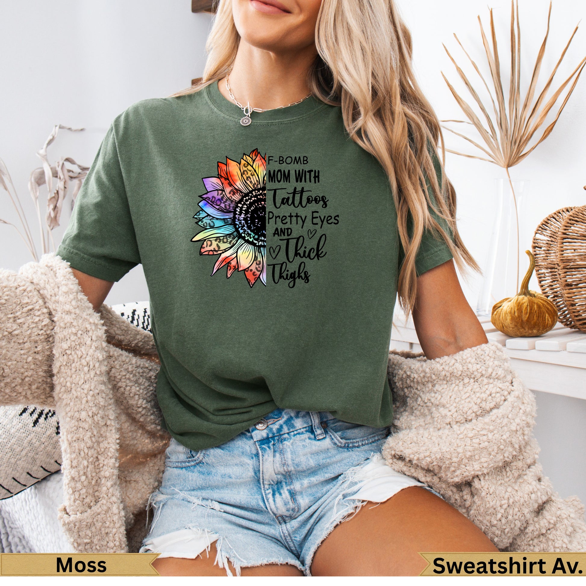 Green t-shirt with floral "F-Bomb Mom with Tattoos Pretty Eyes and Thick Thighs" graphic.