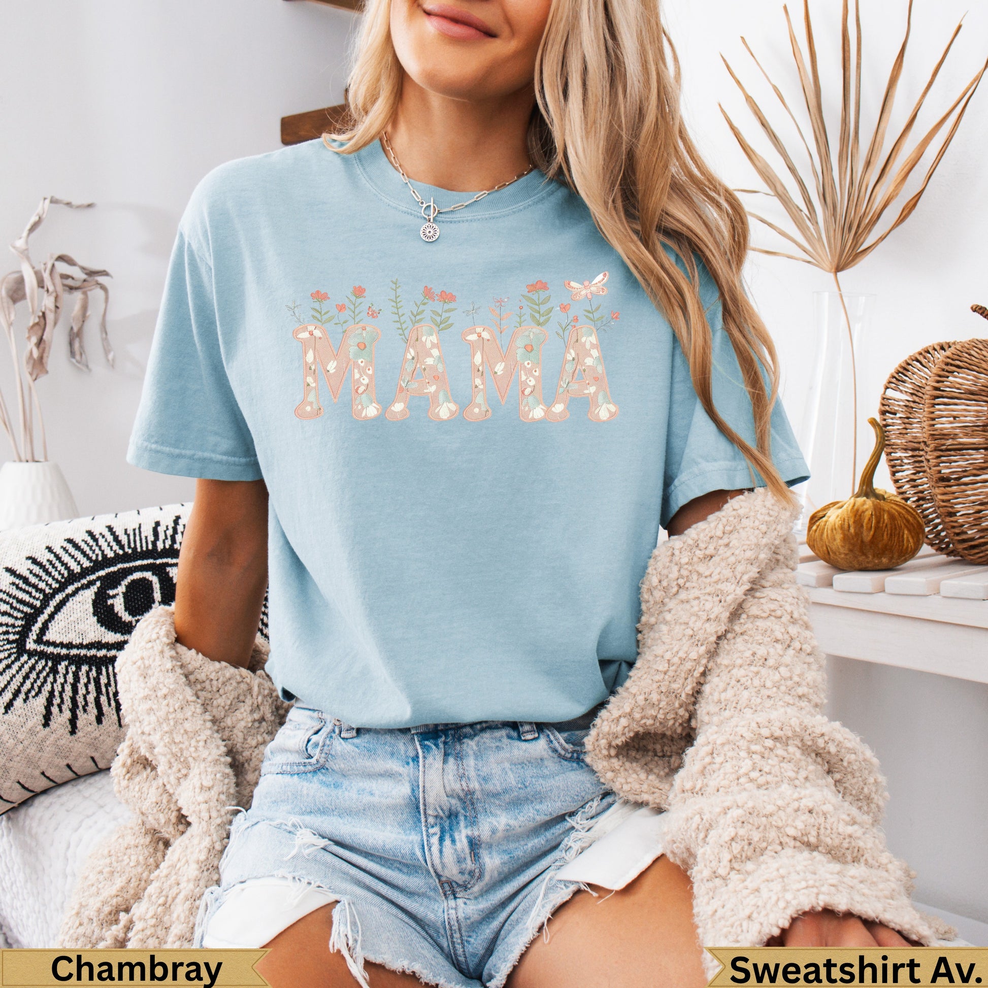Light blue t-shirt with "MAMA" in floral letters, worn by a person.