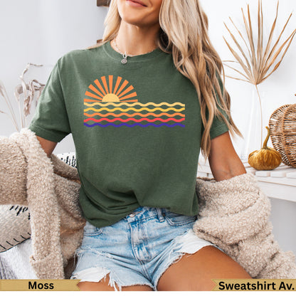 Green t-shirt with a sunset and wavy lines graphic.
