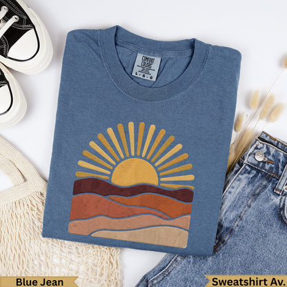 Blue Jean Comfort Colors sweatshirt with a stylized sun and earth tone landscape design.