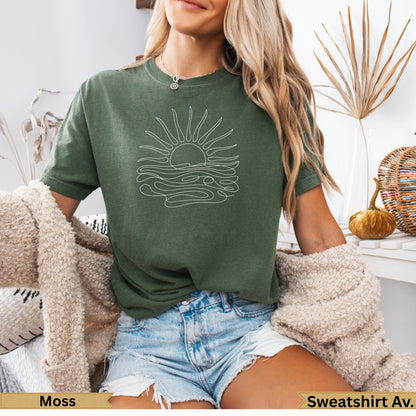 Green t-shirt with a white line drawing of a sun over waves.