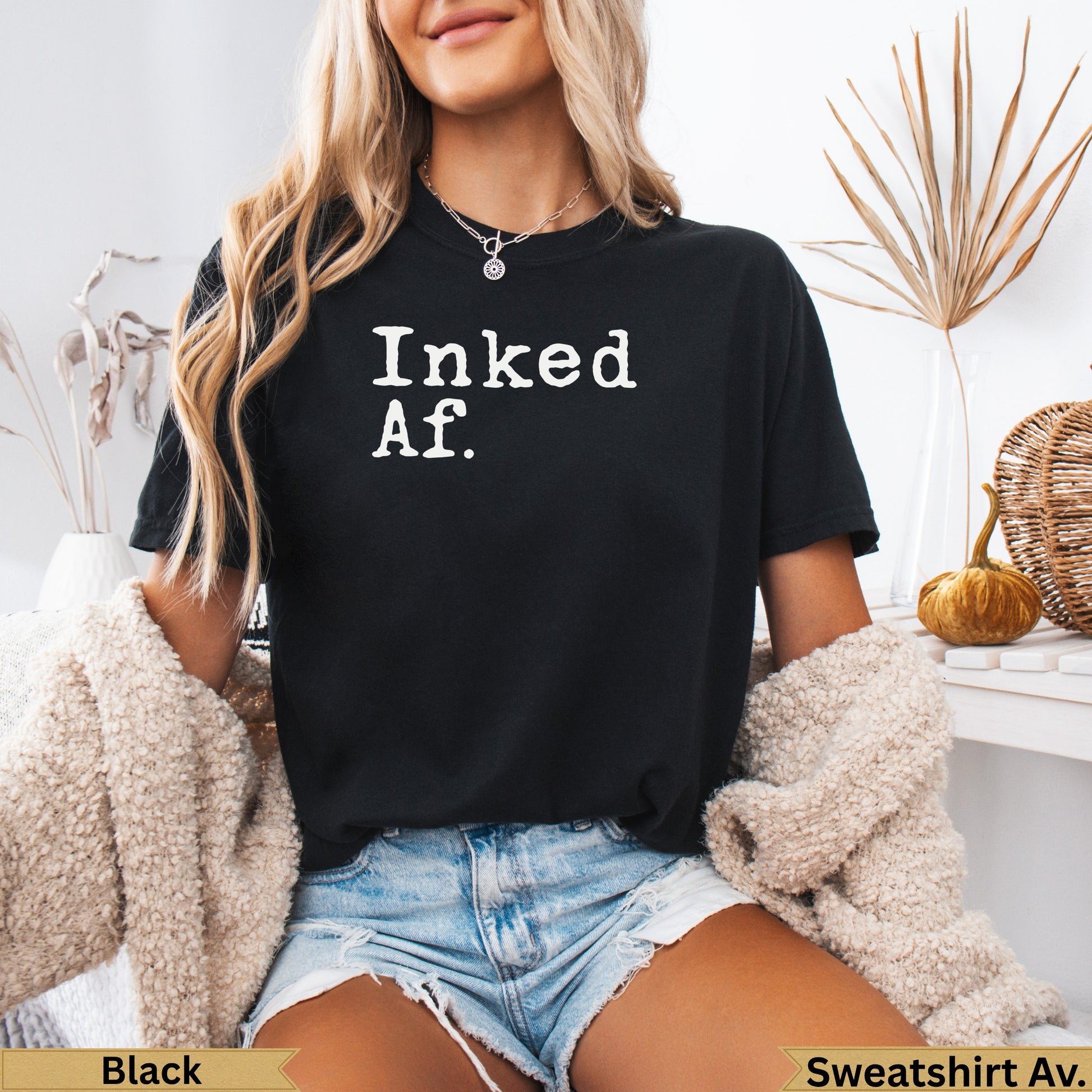 Black t-shirt with white text "Inked Af." worn by a woman.