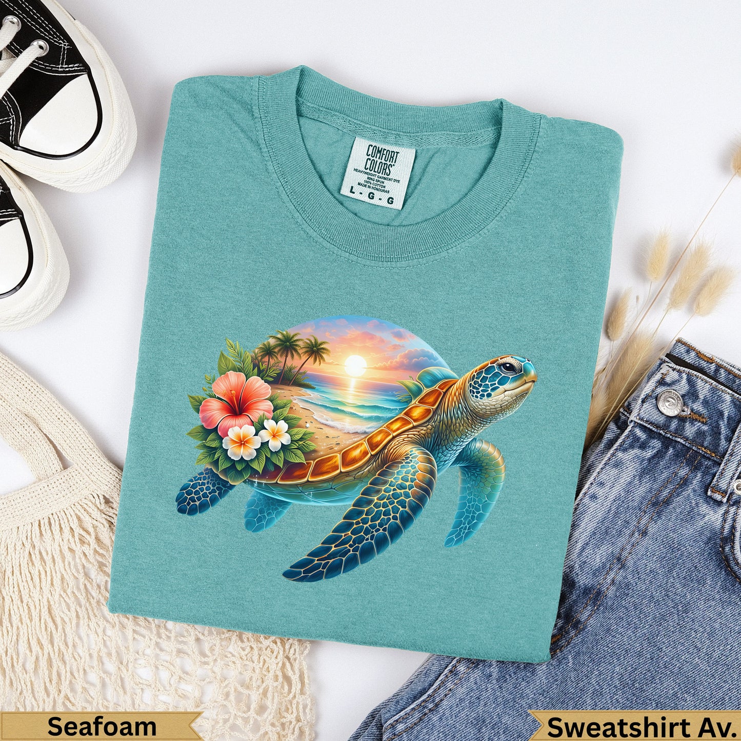 Teal t-shirt with a sea turtle, tropical beach, and sunset graphic.