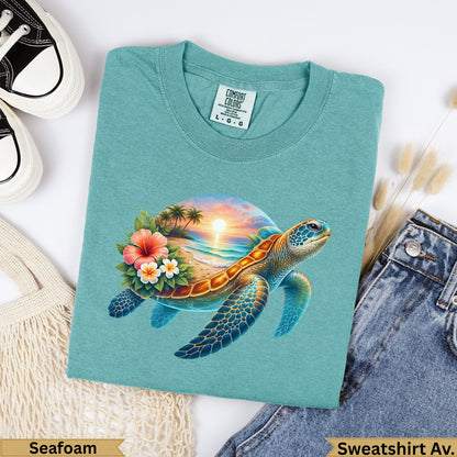 Teal t-shirt with a sea turtle, tropical beach, and sunset graphic.
