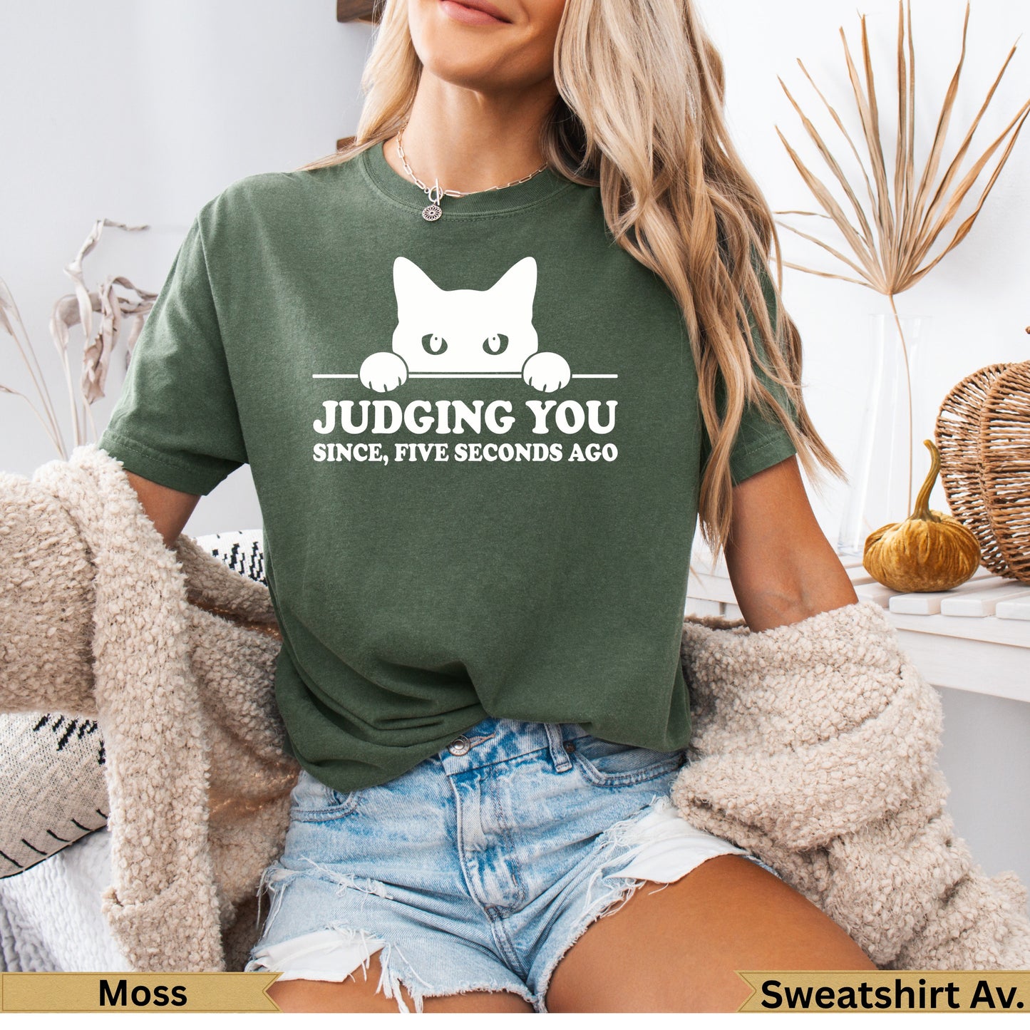 Moss green t-shirt with white cat peeking over text "Judging you since five seconds ago."
