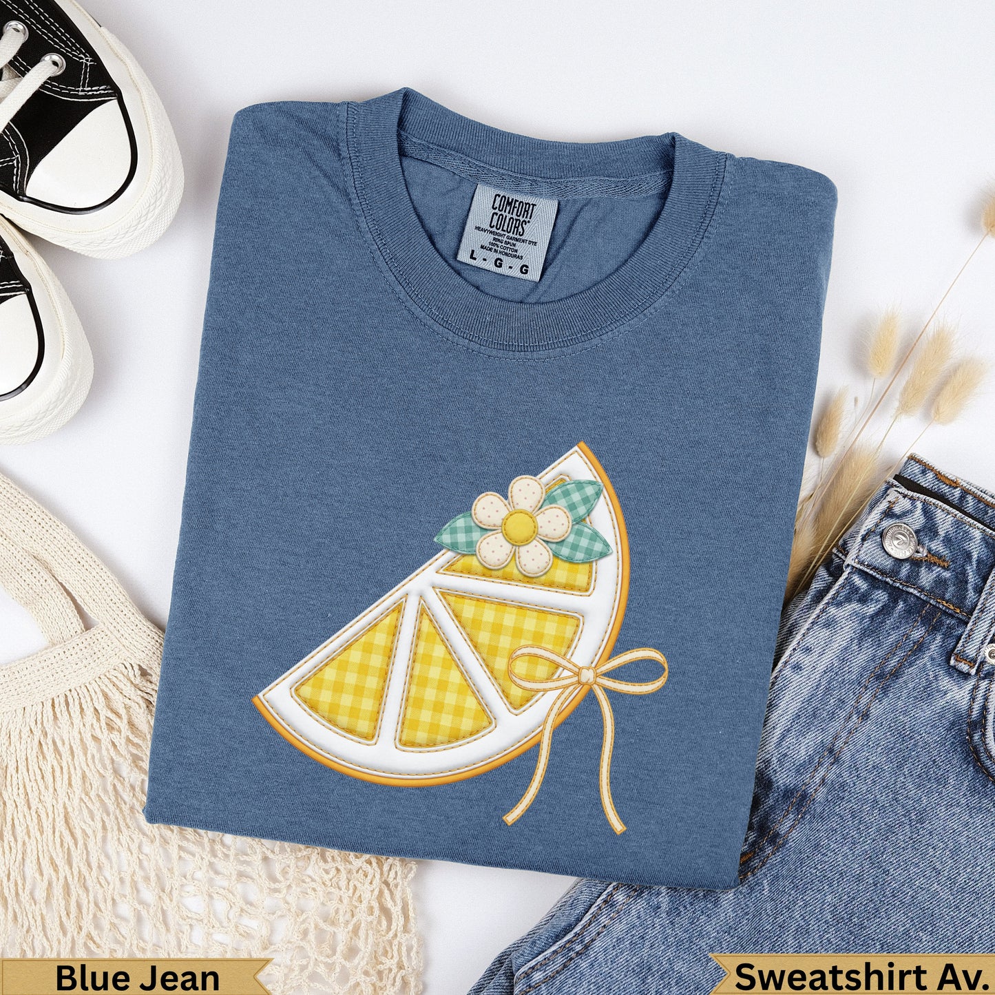 Blue Jean Comfort Colors sweatshirt with a lemon slice graphic and bow.