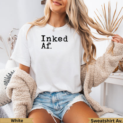 White t-shirt with "Inked Af." text, paired with denim shorts.