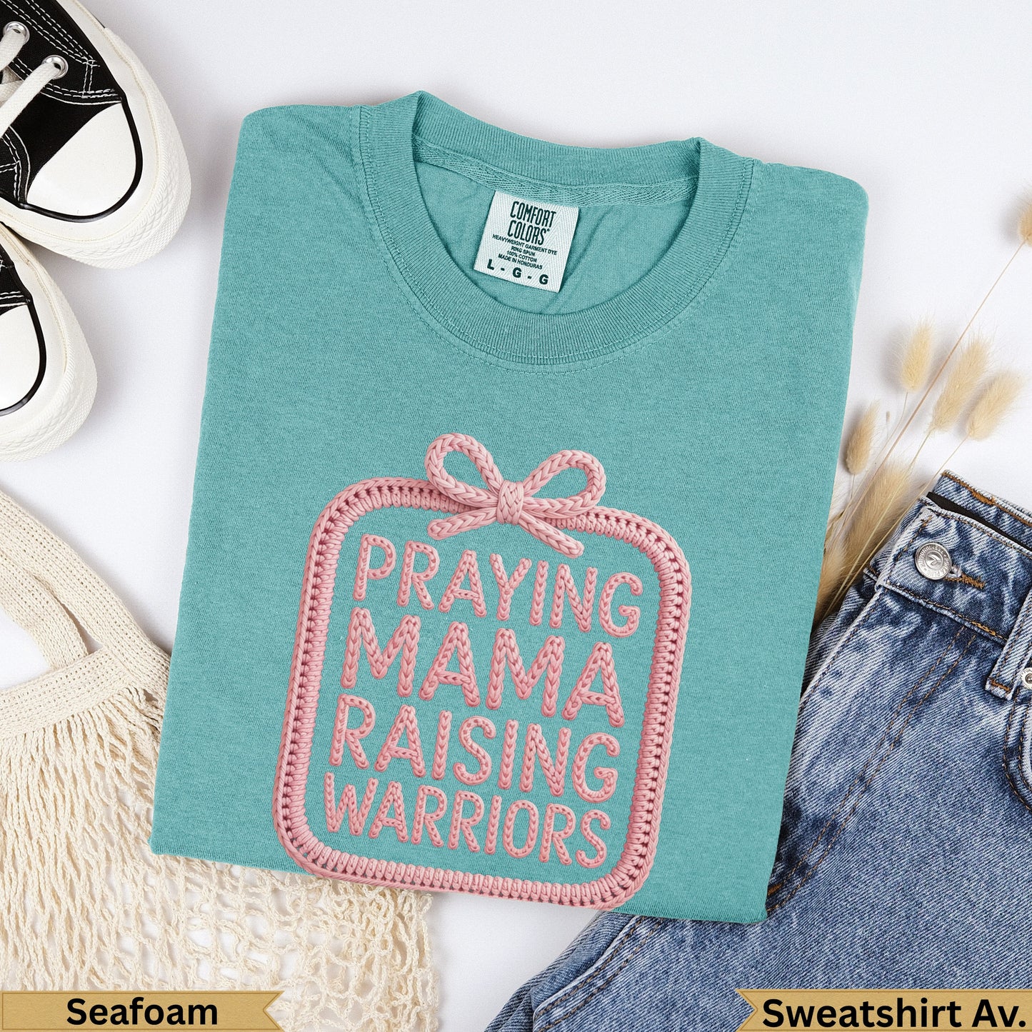 Seafoam Comfort Colors sweatshirt with pink embroidered "Praying Mama Raising Warriors" text.