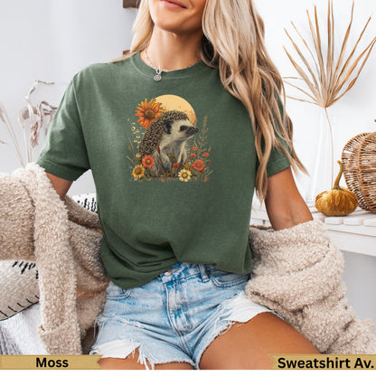 Green t-shirt with hedgehog and floral graphic, worn by a woman.