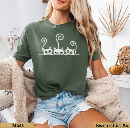 Three minimalist cats with white outlines on a moss green t-shirt.