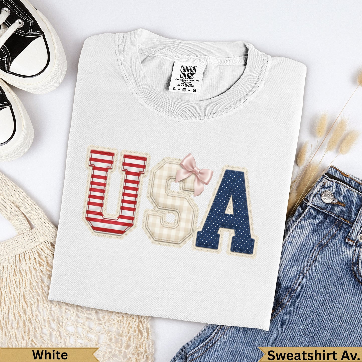 White t-shirt with "USA" appliqued in patriotic red, white, and blue patterns.