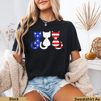 Three cats wearing patriotic American flag designs on a black t-shirt.