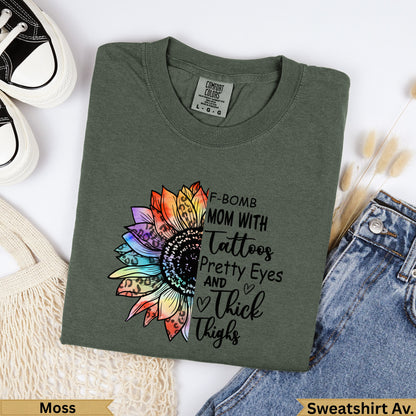 Green t-shirt with "F-Bomb Mom with Tattoos, Pretty Eyes and Thick Thighs" text and sunflower graphic.