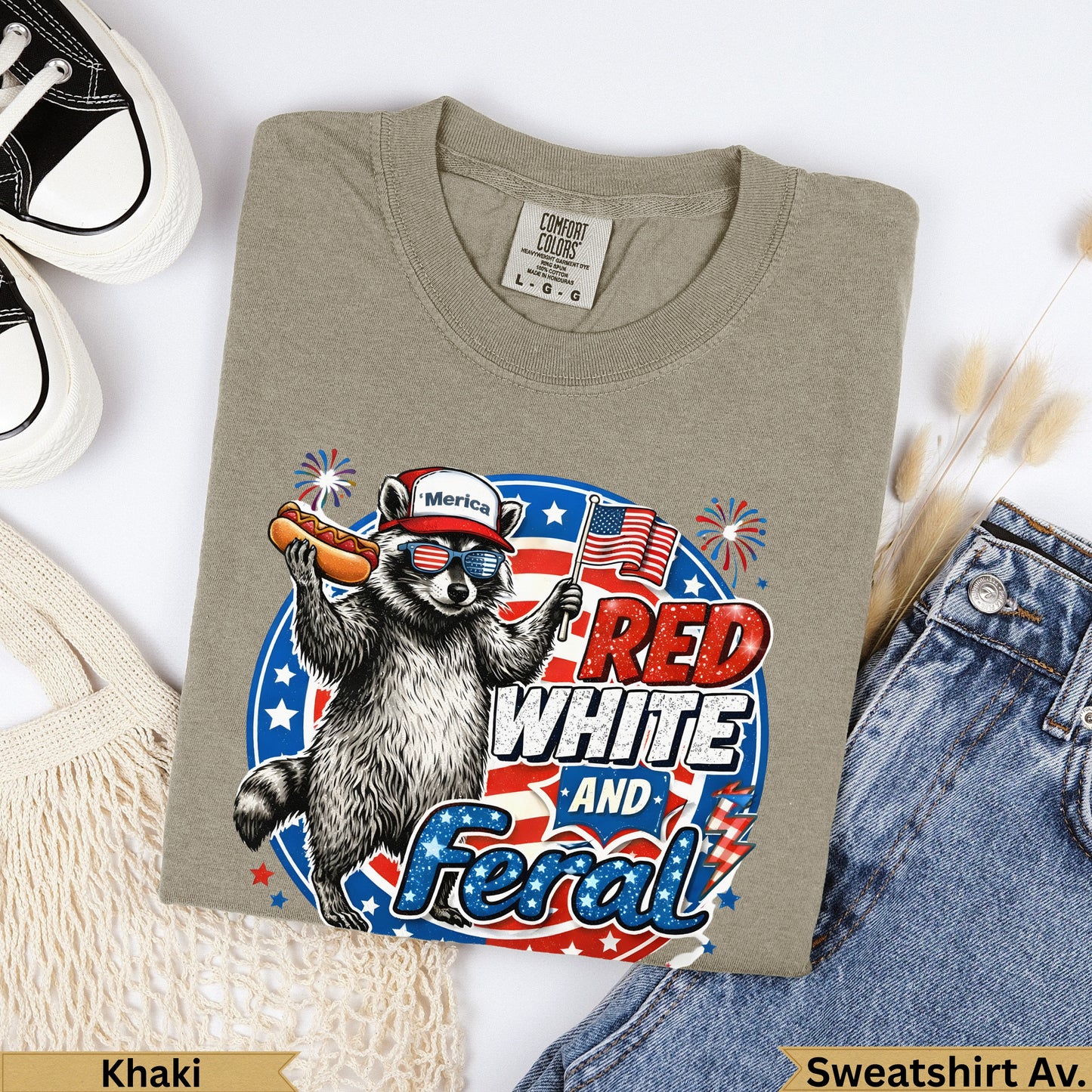 Raccoon in sunglasses eating a hot dog, wearing an American flag shirt, "Red White and Feral" text.