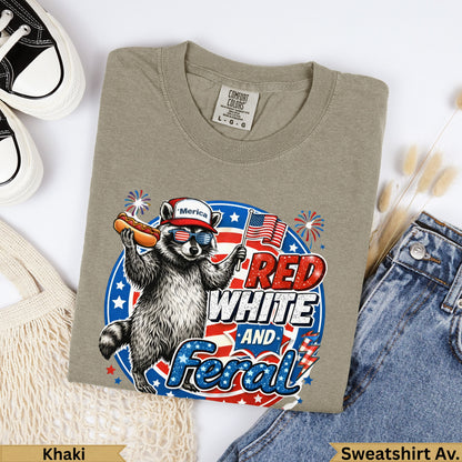 Raccoon in sunglasses eating a hot dog, wearing an American flag shirt, "Red White and Feral" text.