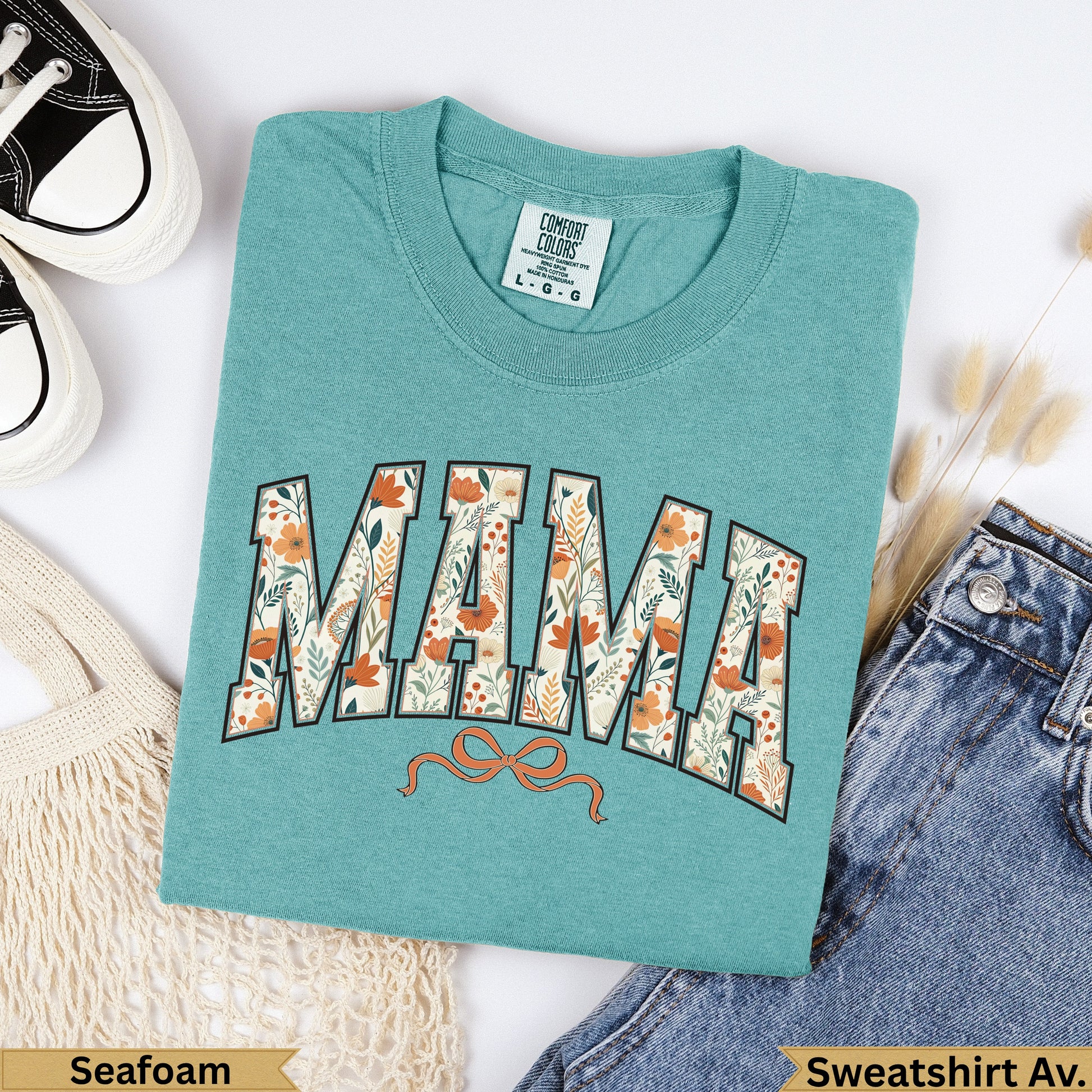 Teal Comfort Colors "Mama" sweatshirt with floral design and orange bow.