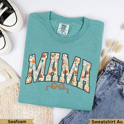 Teal Comfort Colors "Mama" sweatshirt with floral design and orange bow.