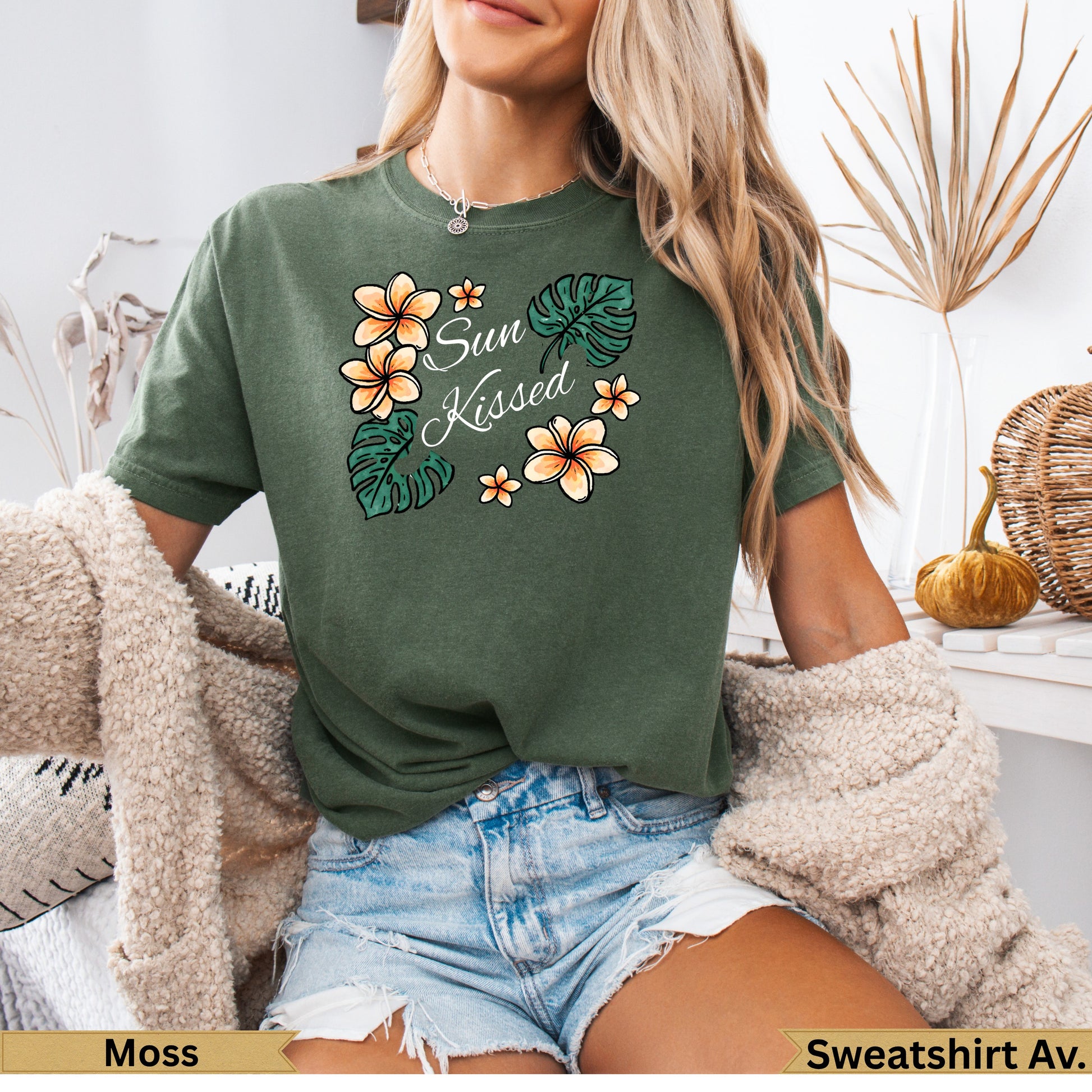 Green t-shirt with "Sun Kissed" text and floral design.