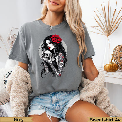Woman with tattooed arms holding skull, red rose in hair.