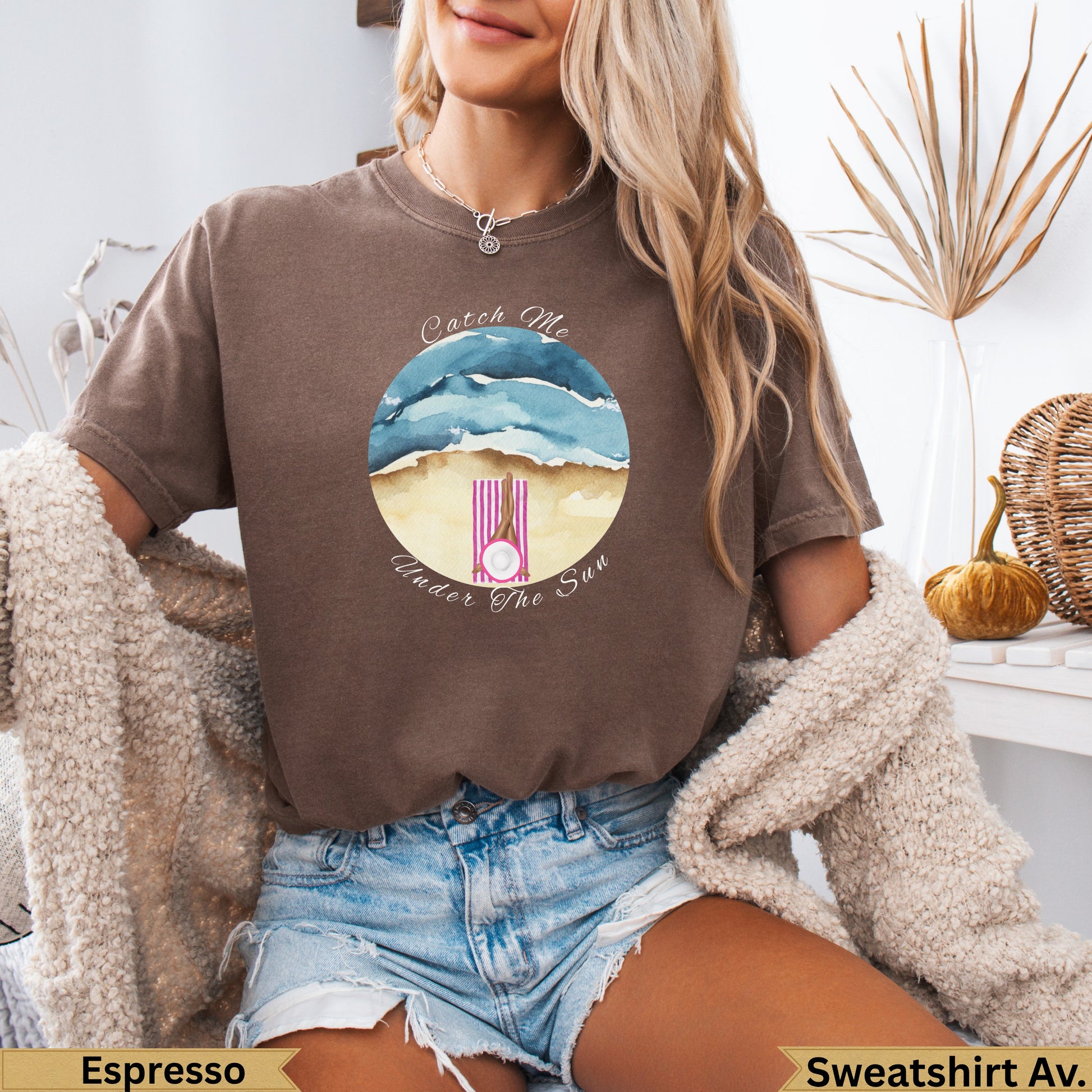 Brown t-shirt with watercolor beach scene and "Catch Me Under The Sun" text.
