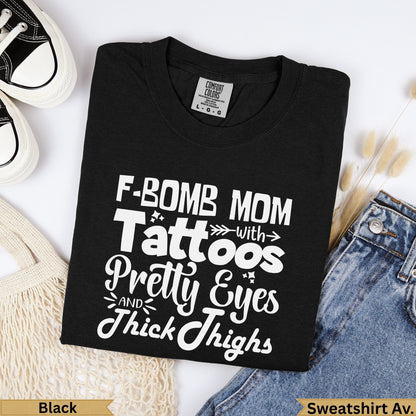 Black Comfort Colors sweatshirt with "F-bomb Mom with Tattoos, Pretty Eyes, and Thick Thighs" text.