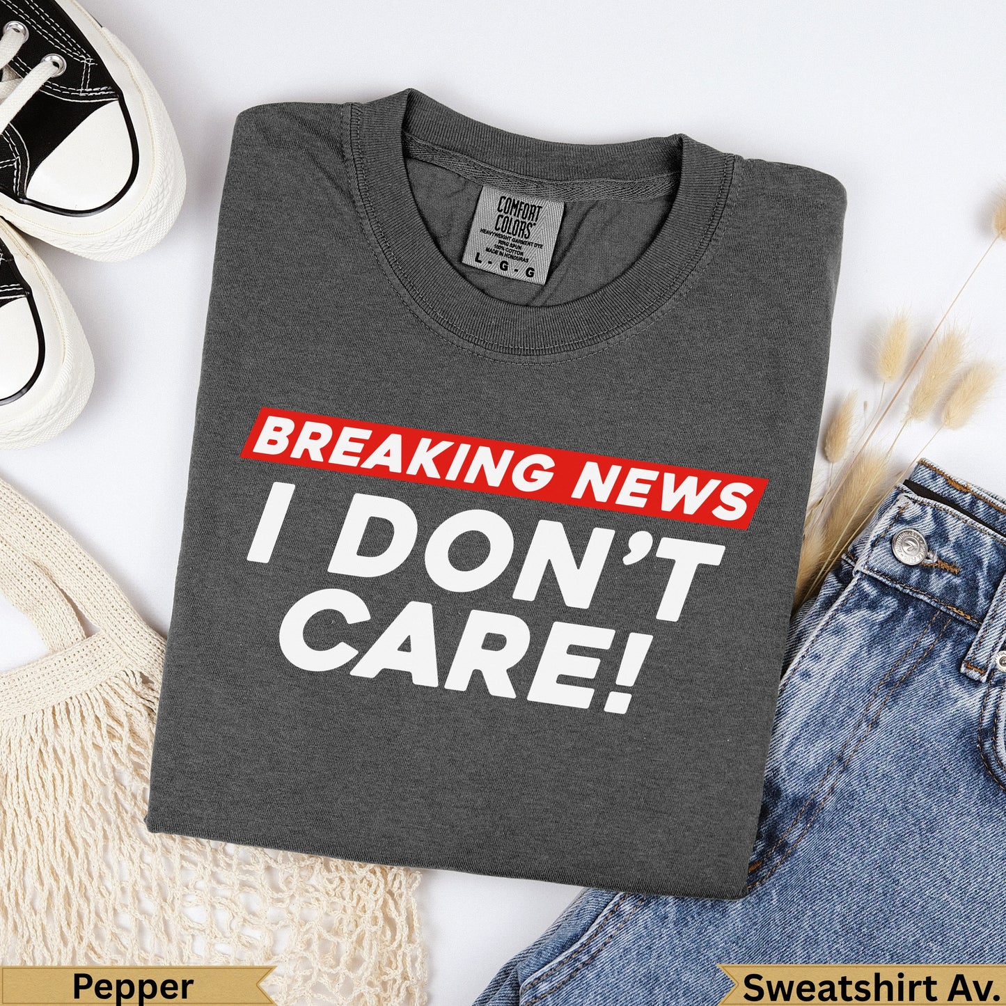 Charcoal grey Comfort Colors sweatshirt with "BREAKING NEWS I DON'T CARE!" text.