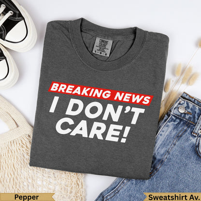 Charcoal grey Comfort Colors sweatshirt with "BREAKING NEWS I DON'T CARE!" text.
