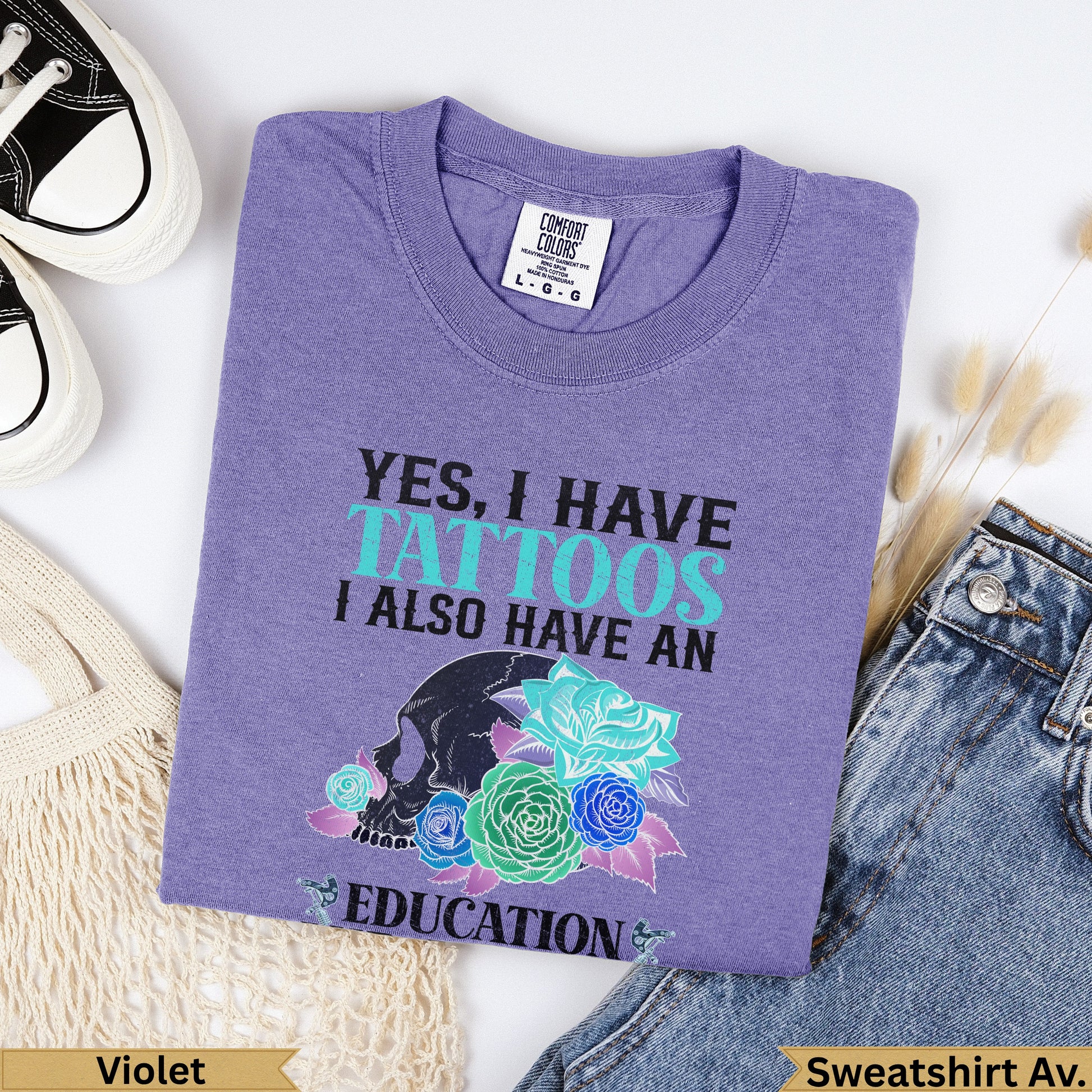 Purple Comfort Colors sweatshirt with skull, roses, and "YES, I HAVE TATTOOS I ALSO HAVE AN EDUCATION" text.