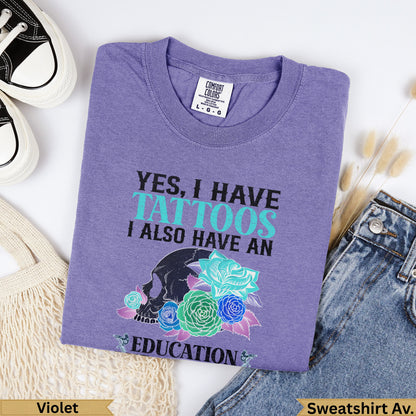 Purple Comfort Colors sweatshirt with skull, roses, and "YES, I HAVE TATTOOS I ALSO HAVE AN EDUCATION" text.