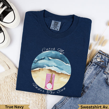 Navy blue graphic t-shirt with "Catch Me Under The Sun" beach graphic.