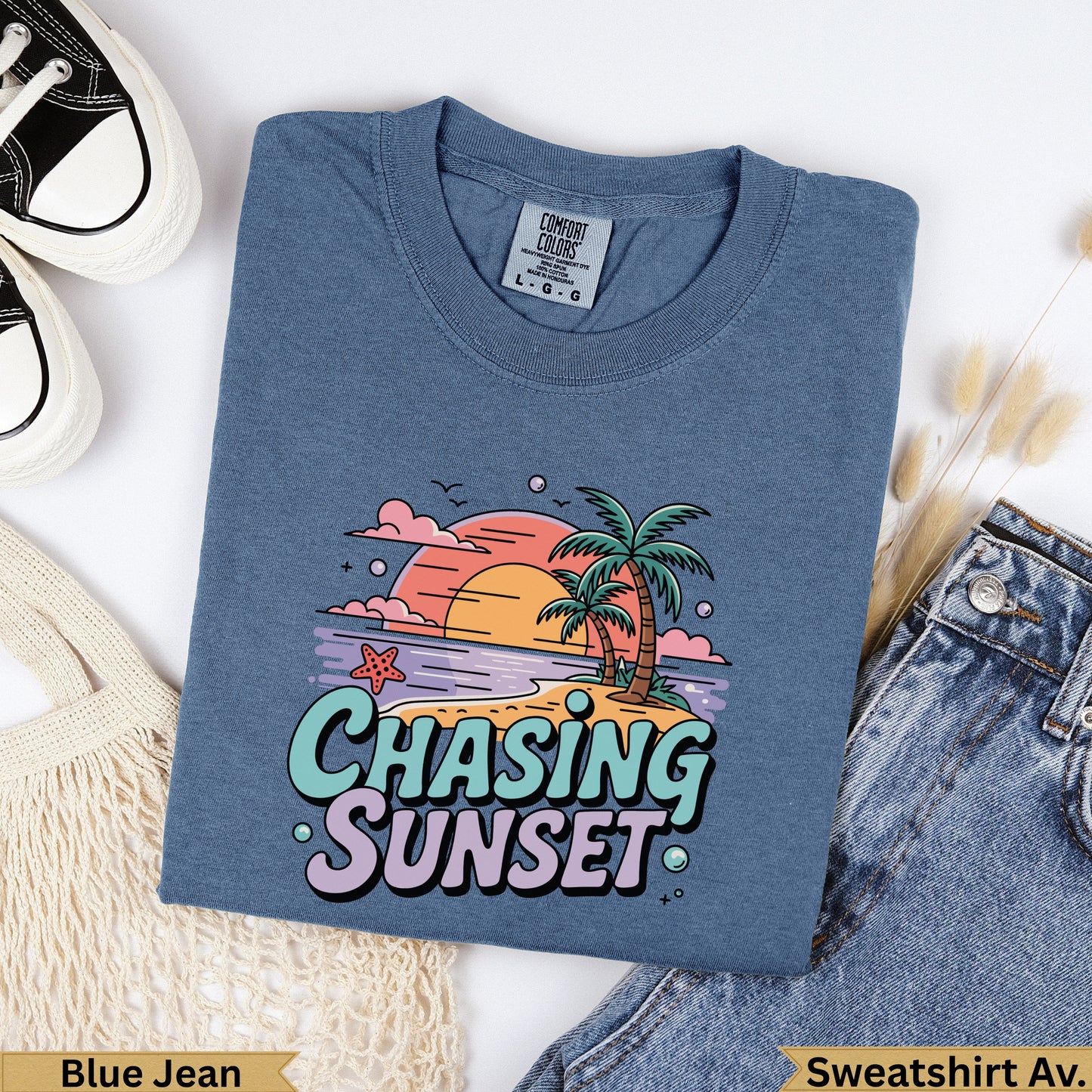 Blue t-shirt with "Chasing Sunset" graphic featuring palm trees and a sunset.
