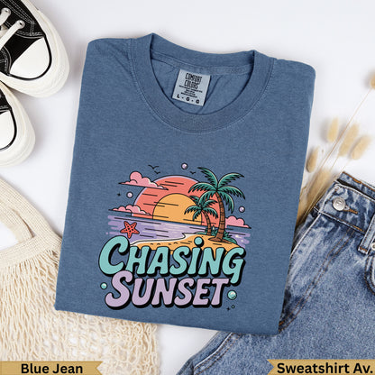 Blue t-shirt with "Chasing Sunset" graphic featuring palm trees and a sunset.