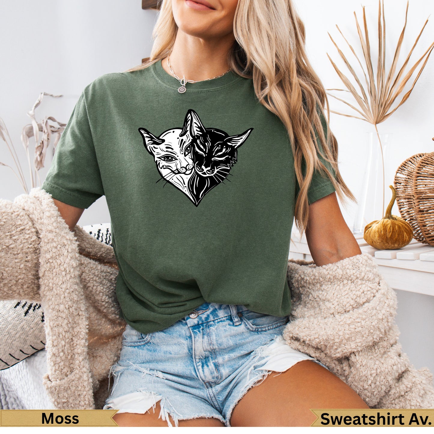 Green t-shirt with split black and white cat face graphic on chest.
