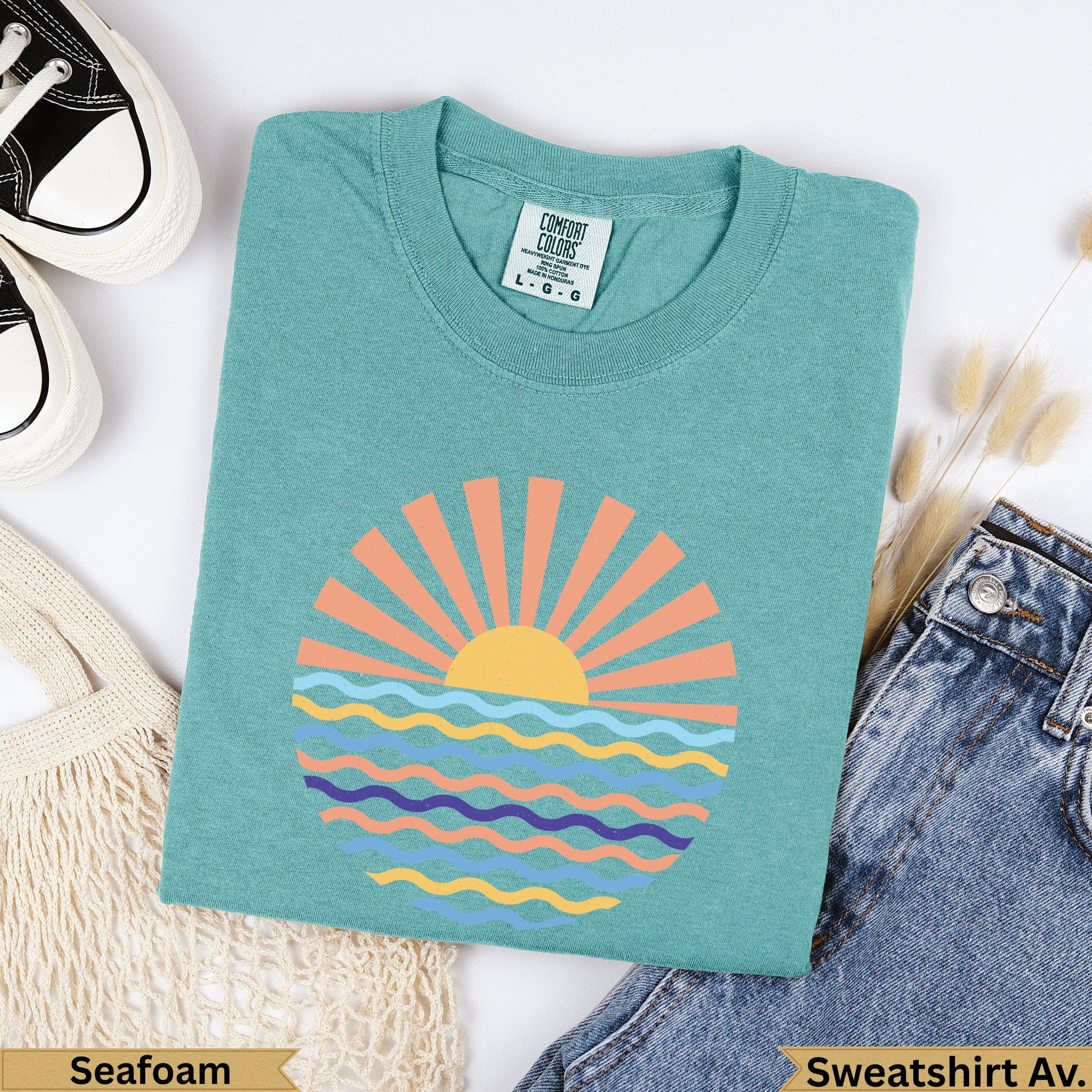 Teal Comfort Colors t-shirt with sun and waves graphic, labeled Seafoam.