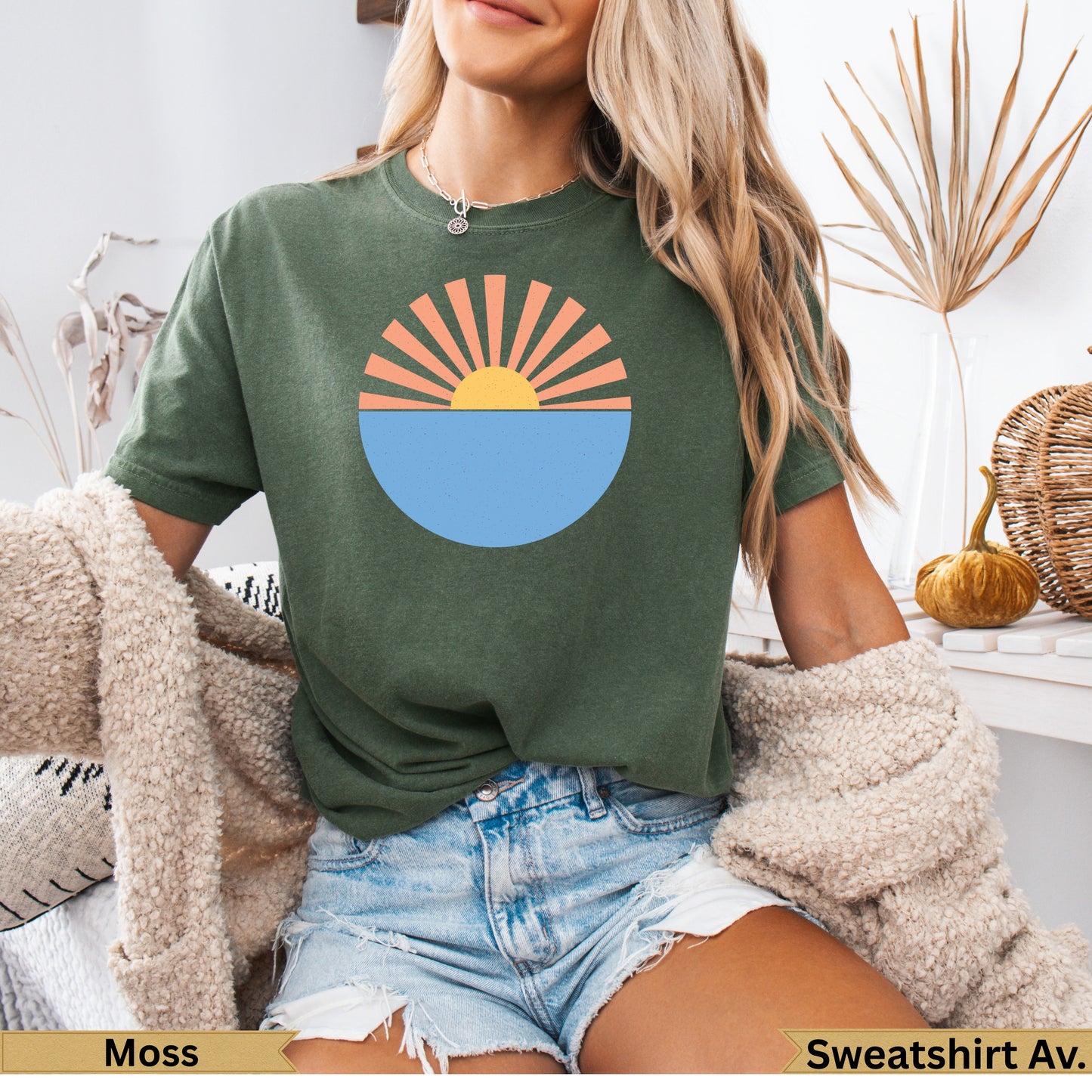 Green t-shirt with sun setting over water graphic.