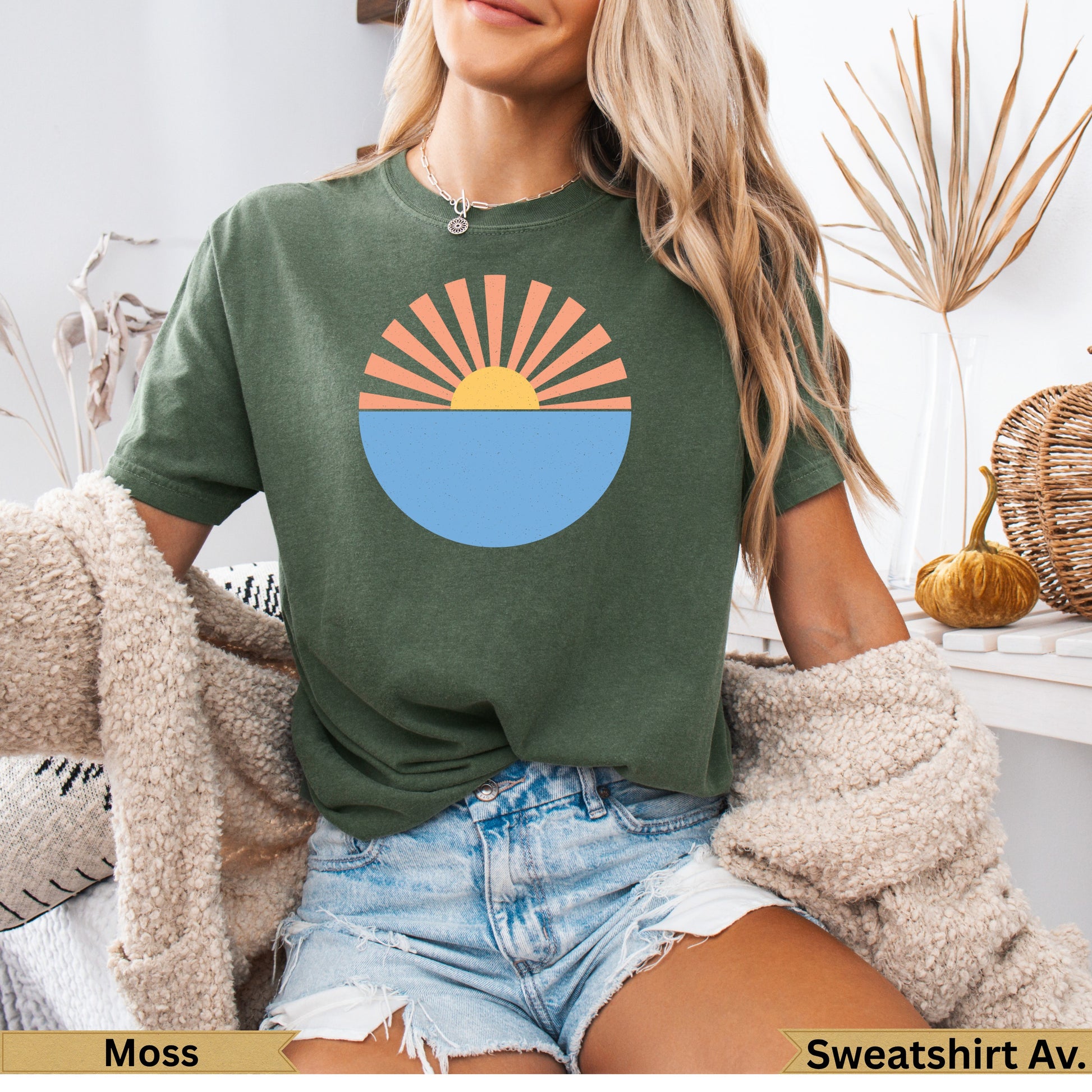 Green t-shirt with sun setting over water graphic.