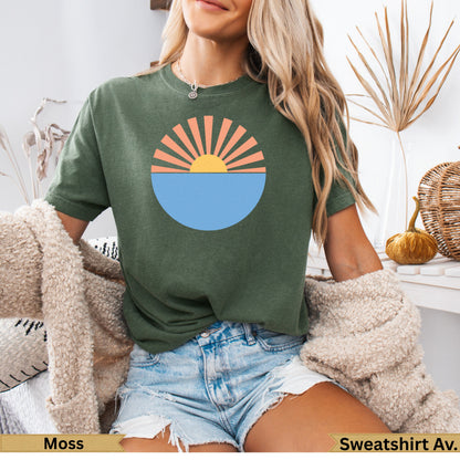Green t-shirt with sun setting over water graphic.