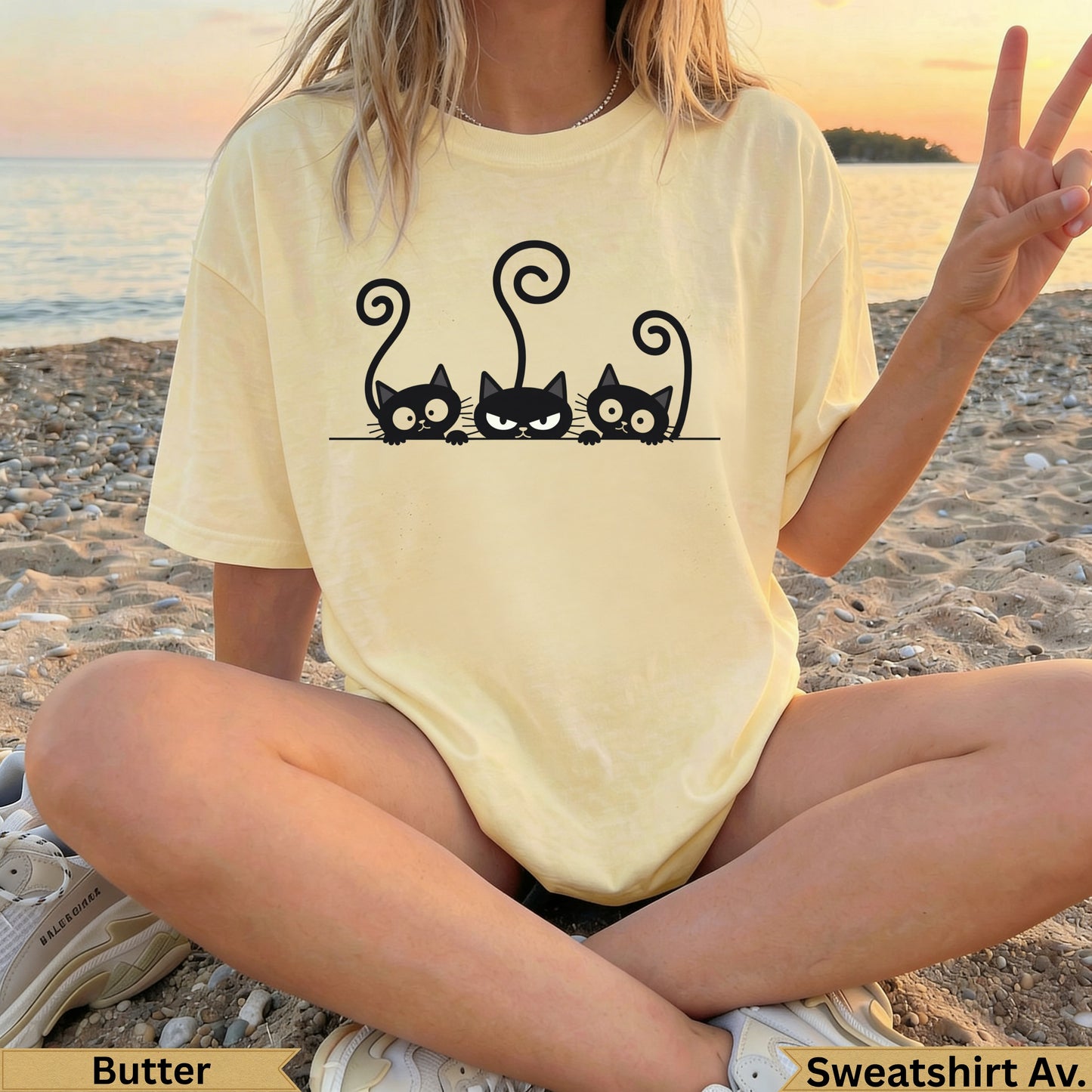 Yellow t-shirt with three black cats peeking over the bottom edge.
