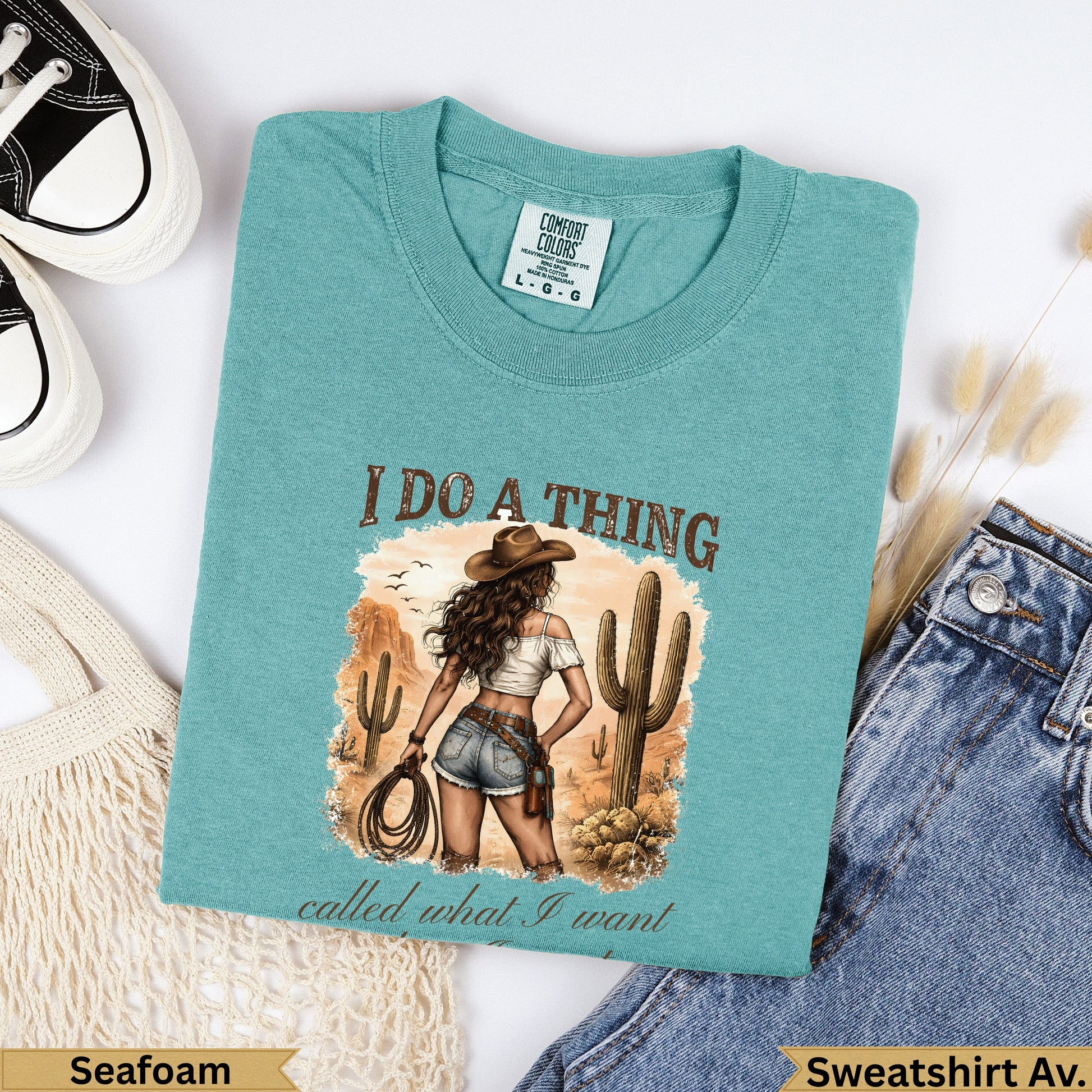 Teal graphic t-shirt with desert scene and "I do a thing called what I want" text.