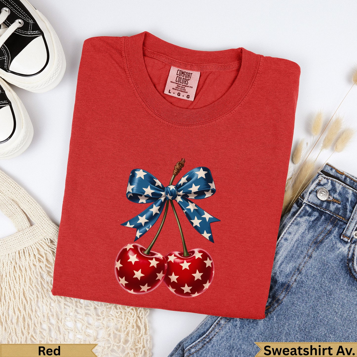 Red crewneck sweatshirt with cherries and star-spangled bow graphic.